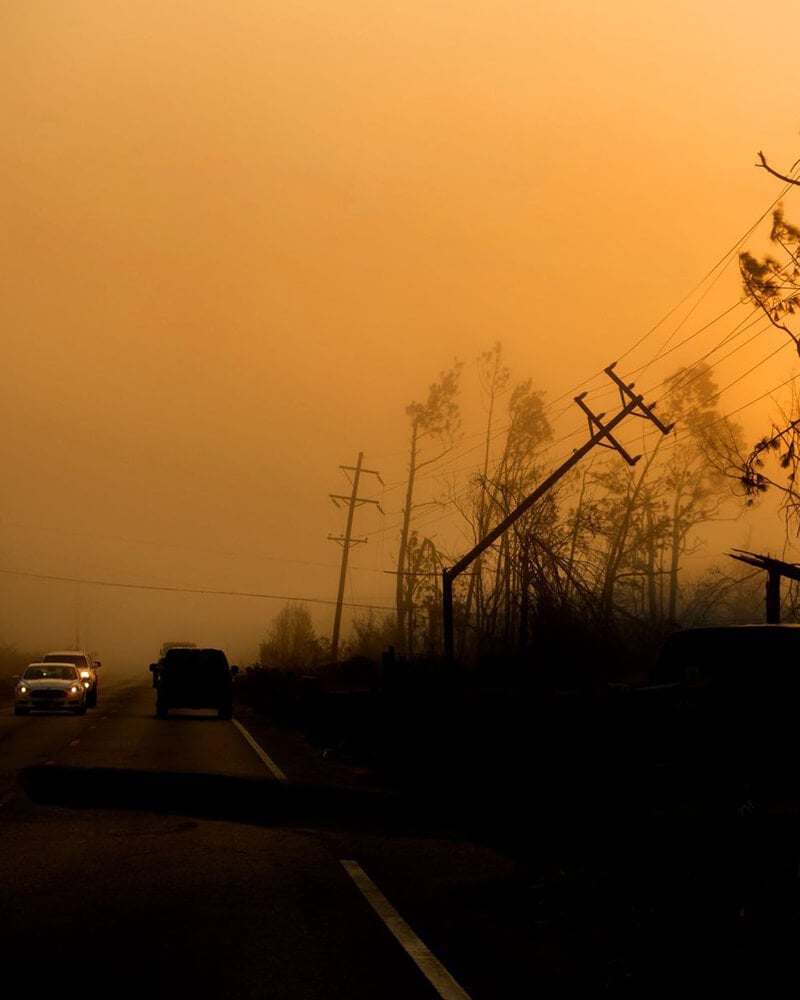Cars passing fallen power lines after a storm, showing emergency communication reliability